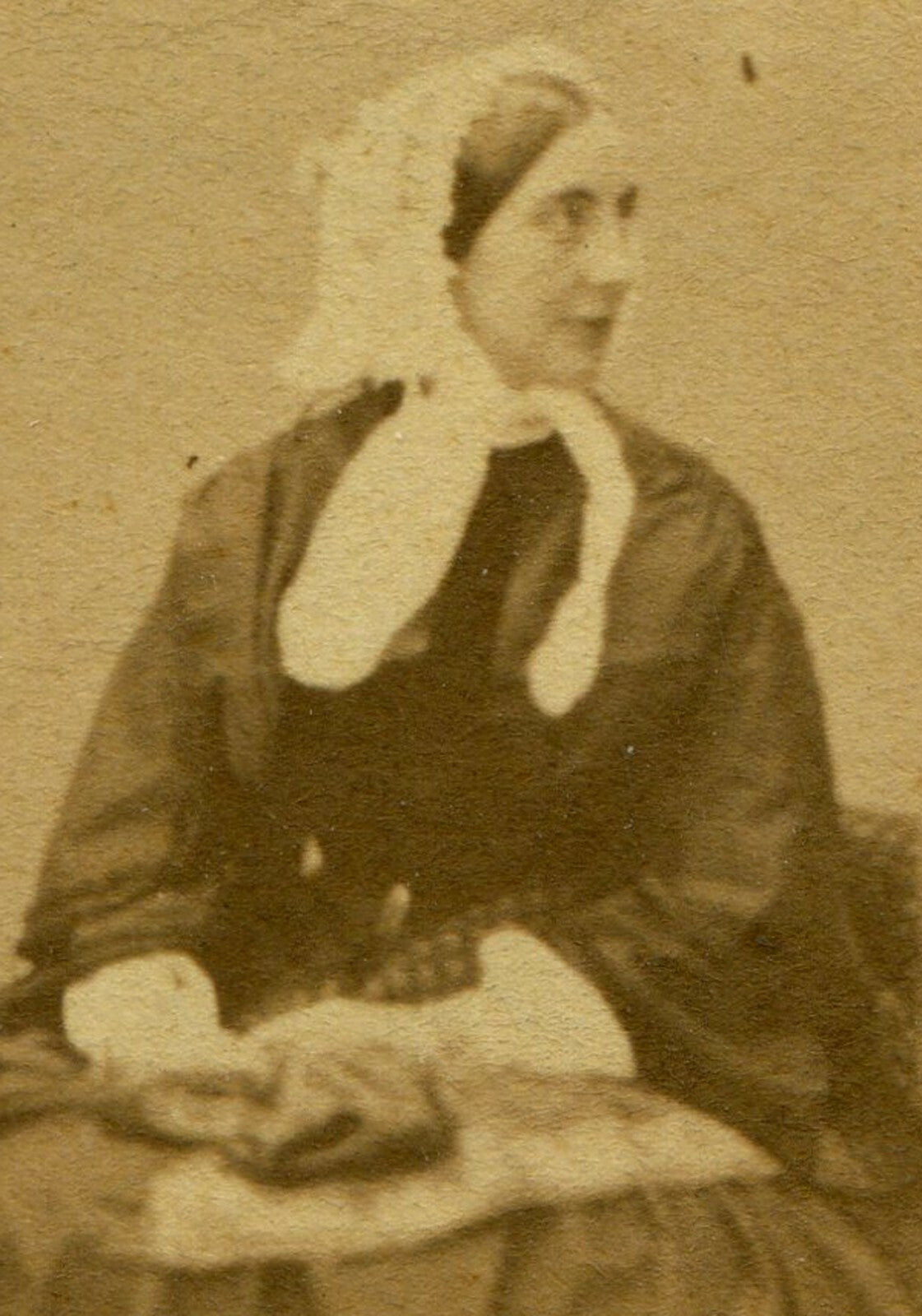 WOMAN IN BONNET, HOLDING ITEMS ON LAP. CDV.