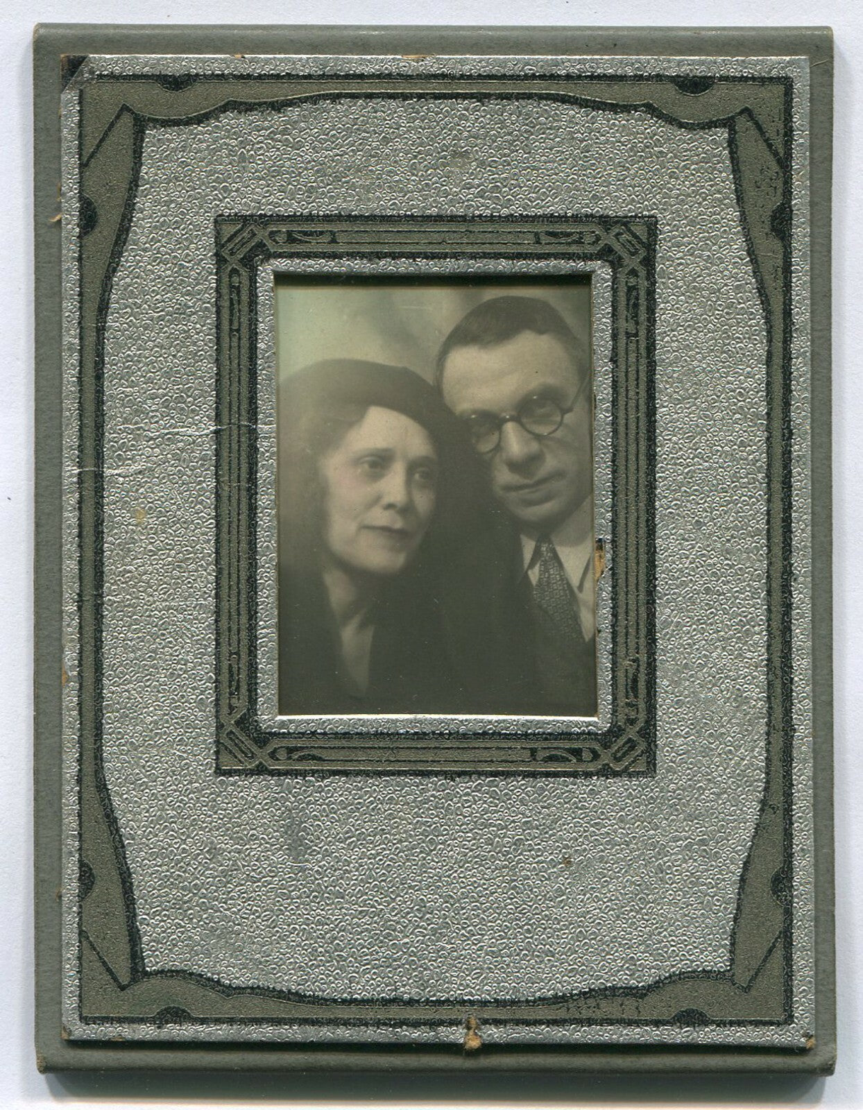 COUPLE, AFFECTIONATE POSE. TINTED PHOTO, ART DECO PAPER FRAME. 4X3 INCHES.