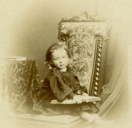 VERY YOUNG GIRL POSED READING A BOOK ON A VERY BIG CHAIR. CDV. JERSEY, U.K.