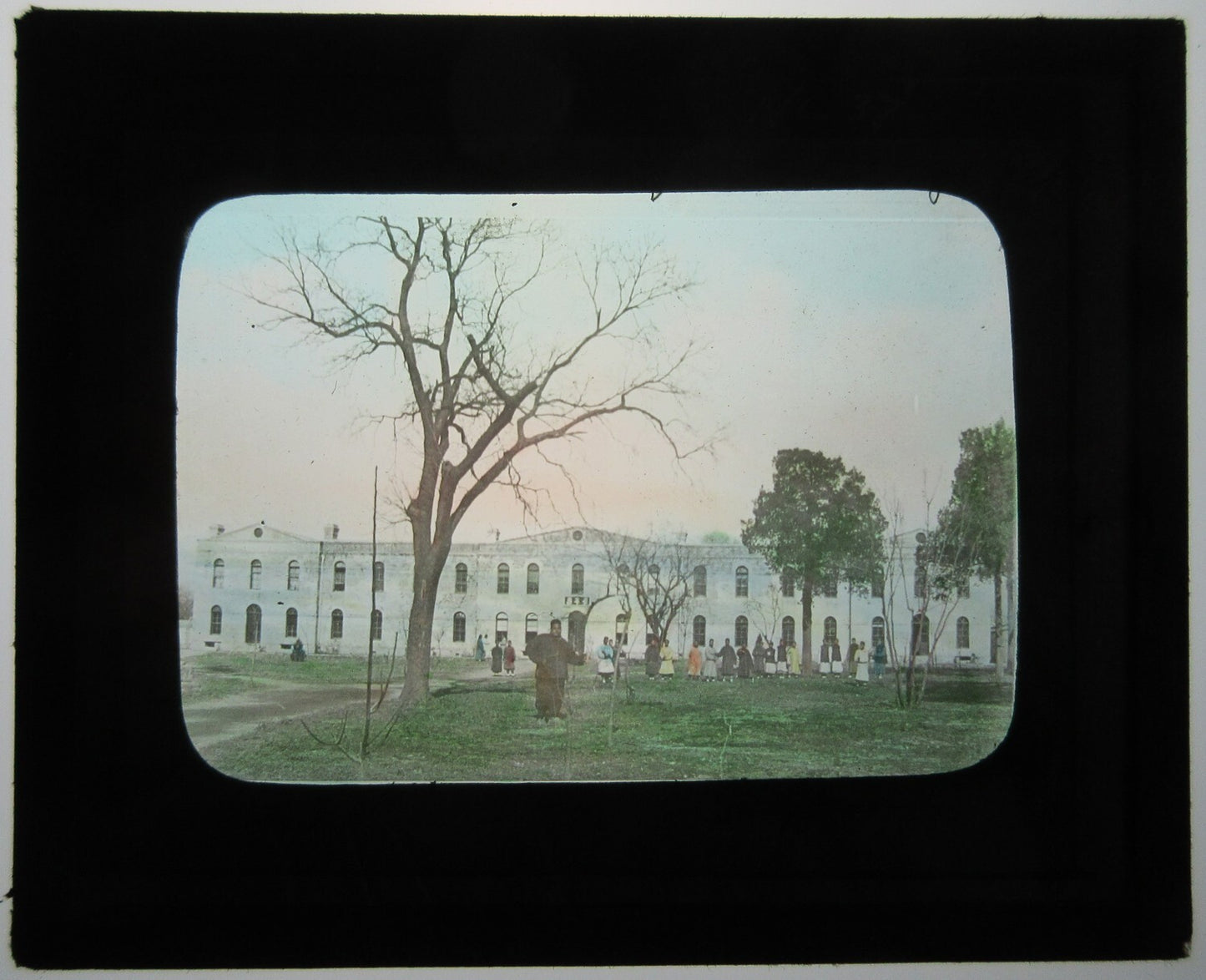AFRICAN AMERICANS OUTSIDE LARGE BUILDING. TINTED LANTERN SLIDE.