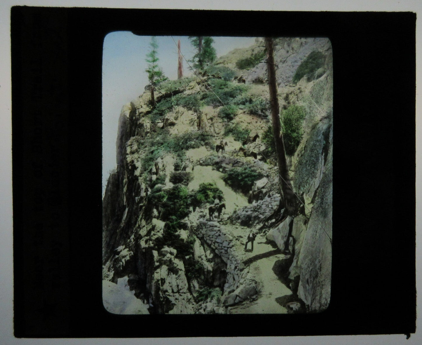 Vintage tinted lantern slide: People on horseback at Glacier Point Trail, Yosemite, photo on glass 3x3.5 in
