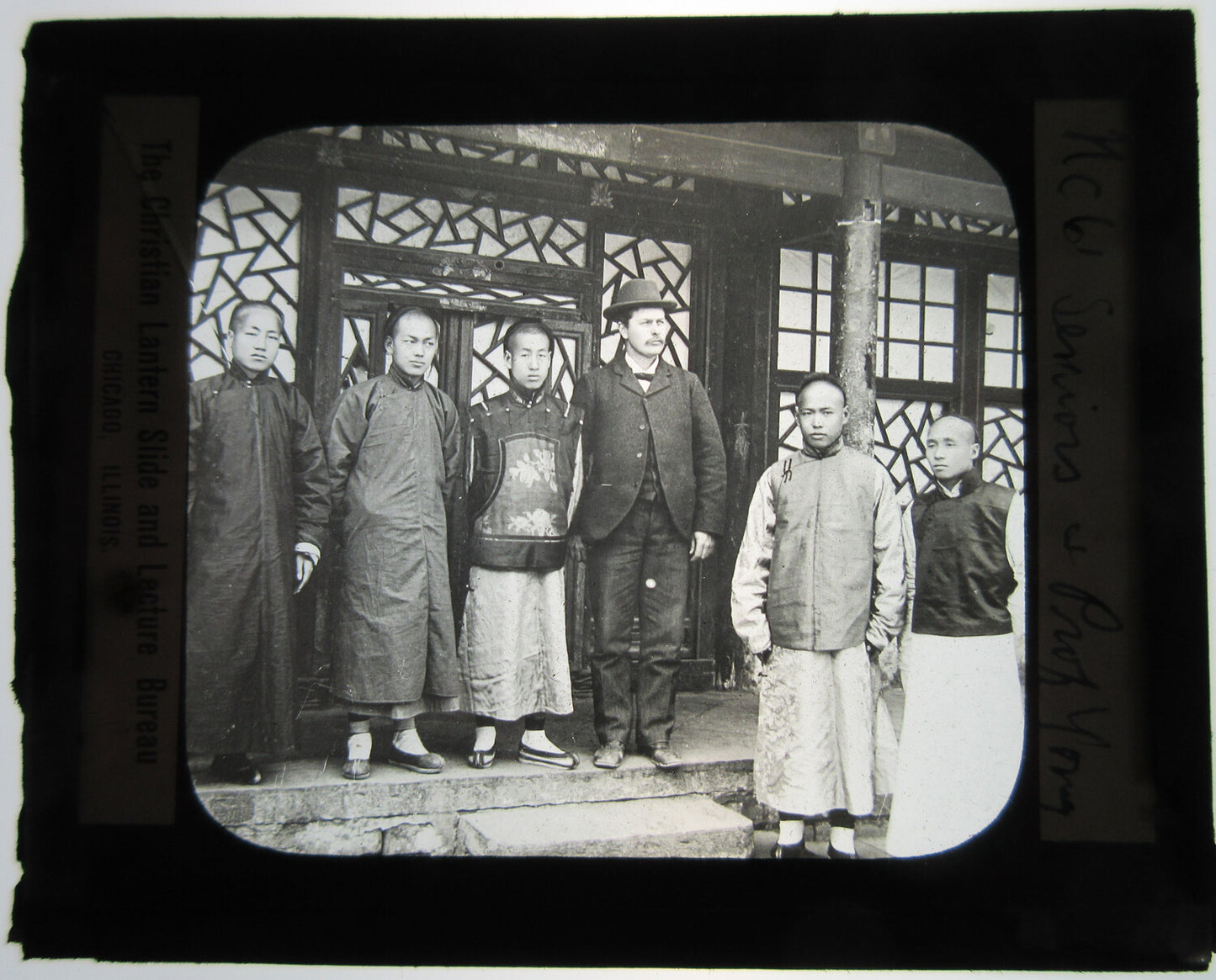 YOUNG MEN IN TRADITIONAL CHINESE CLOTHING POSED W/ WESTERN MAN. LANTERN SLIDE.