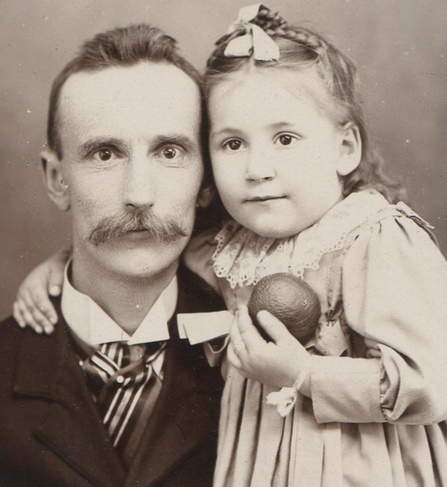 FATHER WITH YOUNG DAUGHTER, HOLDING A TOY. CABINET CARD.