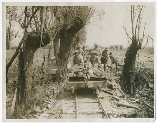 WOUNDED BRITISH TROOPS MOVING ALONG LIGHT RAIL. WWI. (8X10 REPRINT)