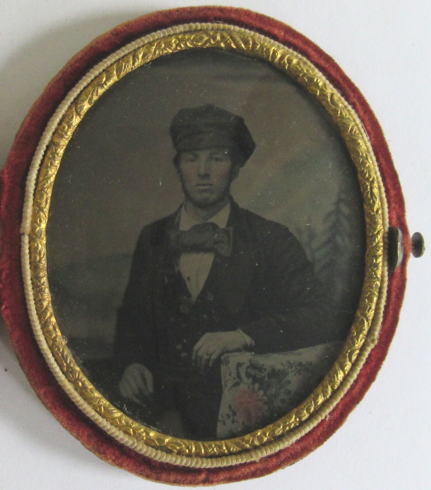 MAN,FISHERMAN CAP, BOW TIE. TINTED, PAINTED BACKGROUND, 9TH PLATE OVAL TINTYPE,
