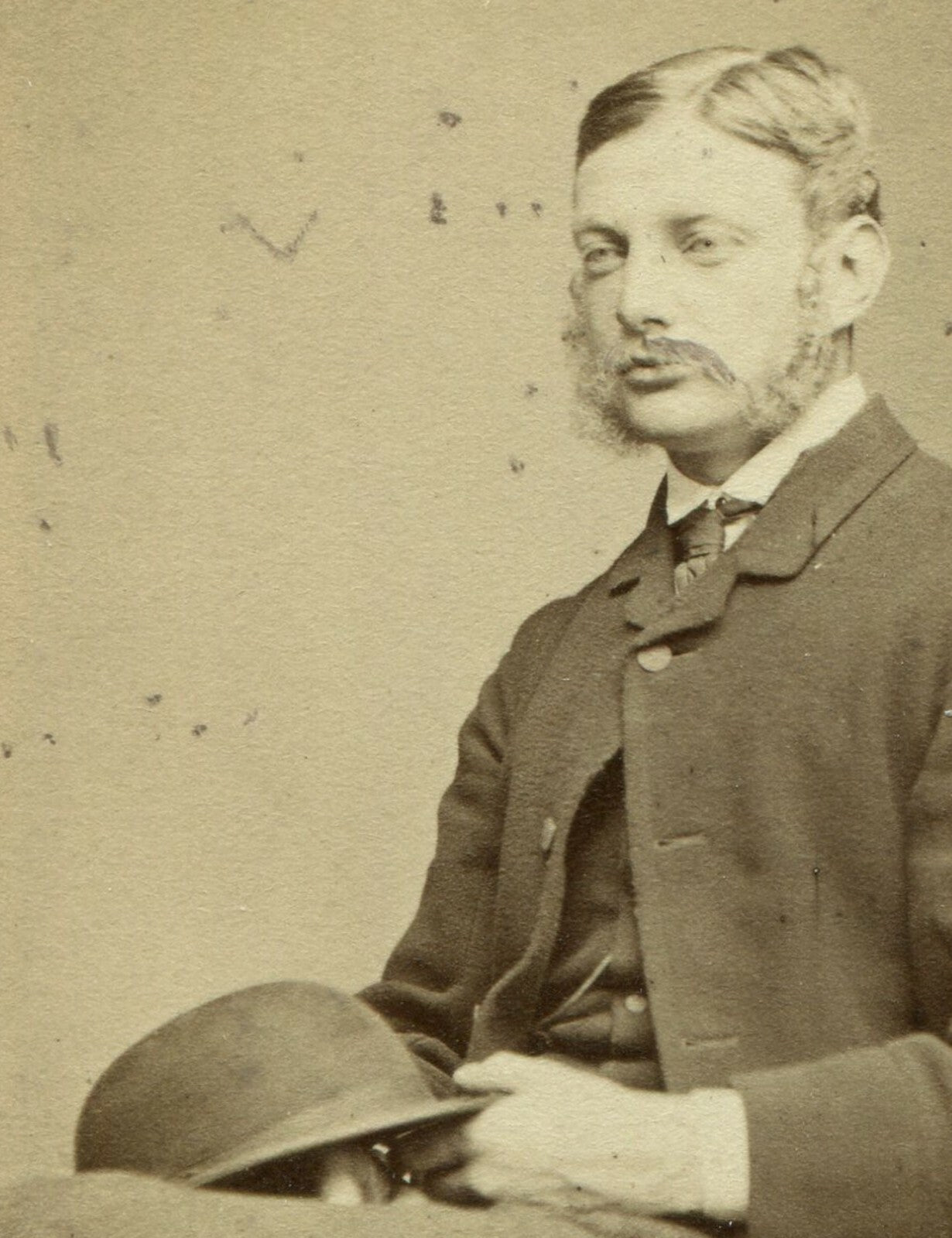 MAN W/MUTTON CHOPS, SEATED POSE HOLDING BOWLER HAT. CDV. JERSEY, U.K.