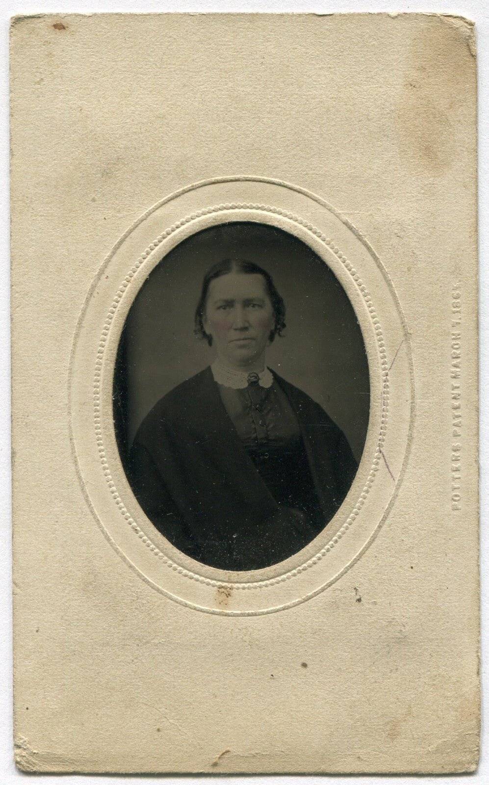 WOMAN, SHORT HAIR, LACE COLLAR. TINTED TINTYPE IN PERIOD PAPER MAT.