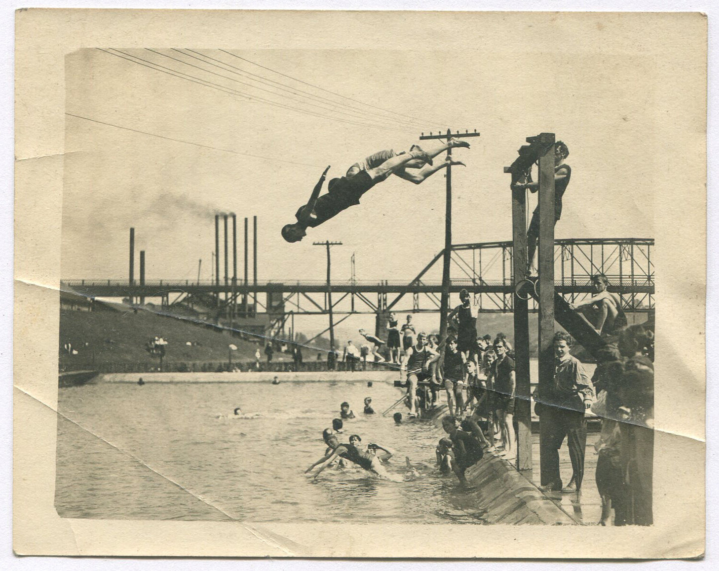 BOYS DIVING INTO RIVER/POOL NEAR INDUSTRIAL SITE. 5X4 B&W. 1900-20s.