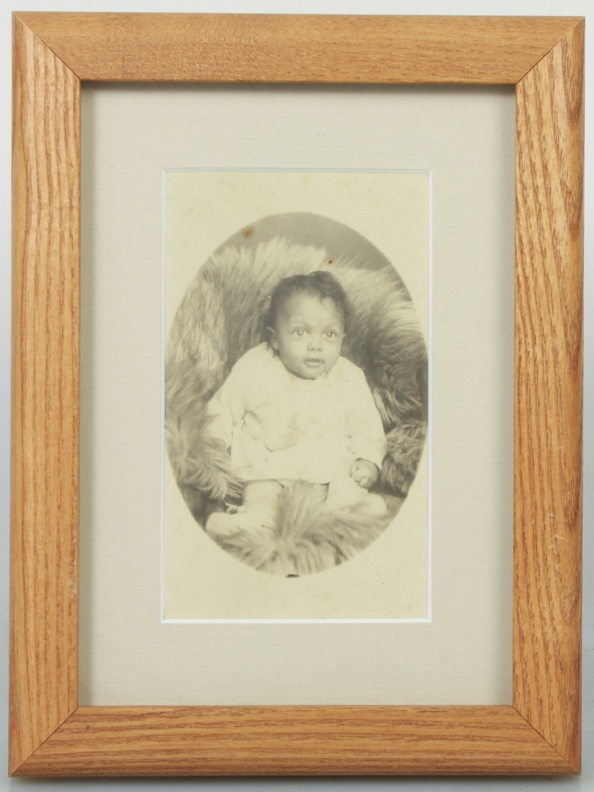 AFRICAN AMERICAN BABY POSED ON FUR BLANKET. CABINET CARD IN 5X7 FRAME.