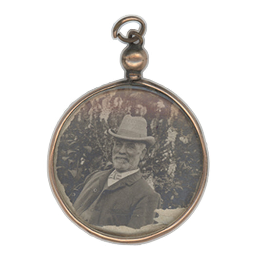 Round pendant with vintage portrait of a man wearing a hat on a white background