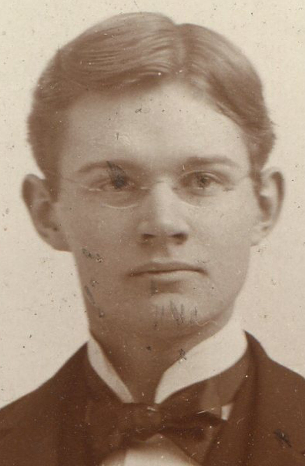HANDSOME YOUNG MAN WEARING GLASSES, RELAXED POSE. BUFFALO, N.Y.