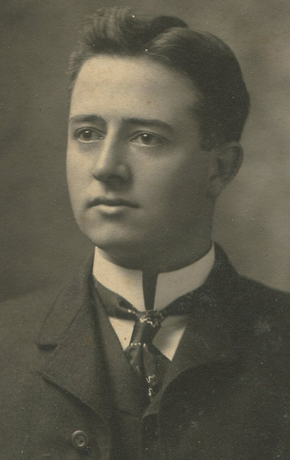 GOOD LOOKING MAN WITH PAINFUL COLLAR AND CURIOUS JEWELRY. SILVER PRINT, 1900.