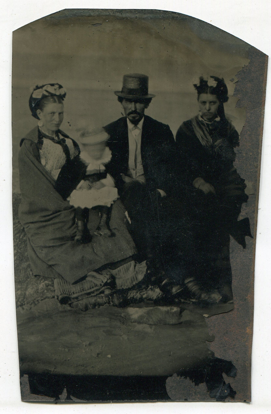 SHADY LOOKING FAMILY, ALL IN HATS. BABY IS A BLUR. TINTYPE.