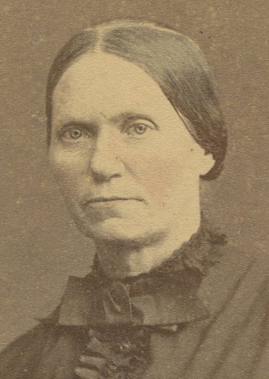 WOMAN POSED AT TABLE WITH BOOK. TINTED OVAL ALBUMEN. 7.5 X 5.25 INCHES.