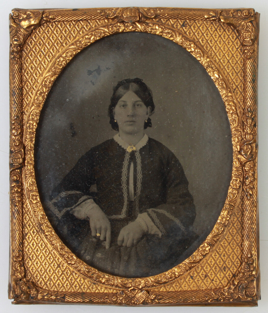 WOMAN, SERIOUS EXPRESSION, GOLD TONED JEWELRY.  TINTED AMBROTYPE, 6TH PLATE.