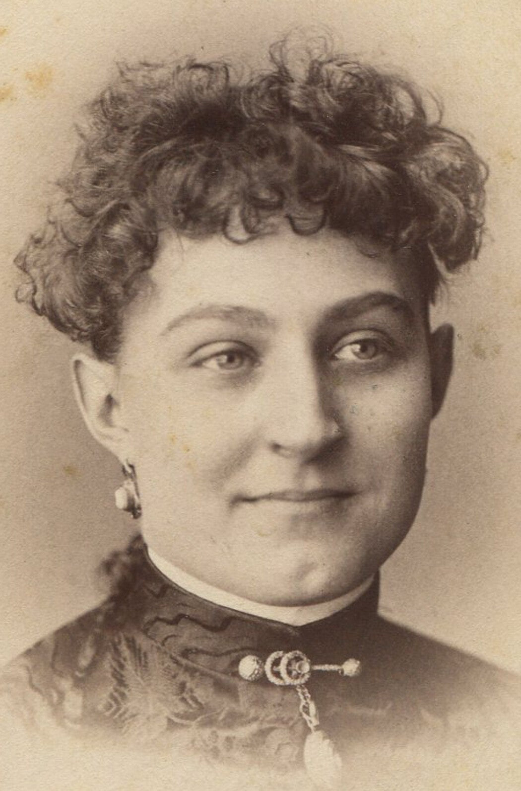 Vintage cabinet card photo: Woman with bright smile and curly top hair --