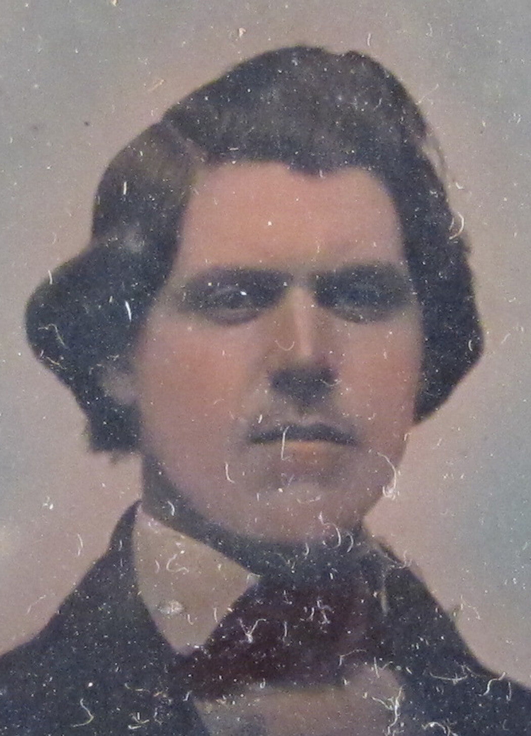MAN W/DARK THICK HAIR, DEEP SET EYES. 6TH PLATE TINTED AMBROTYPE, GLASS, FOIL.