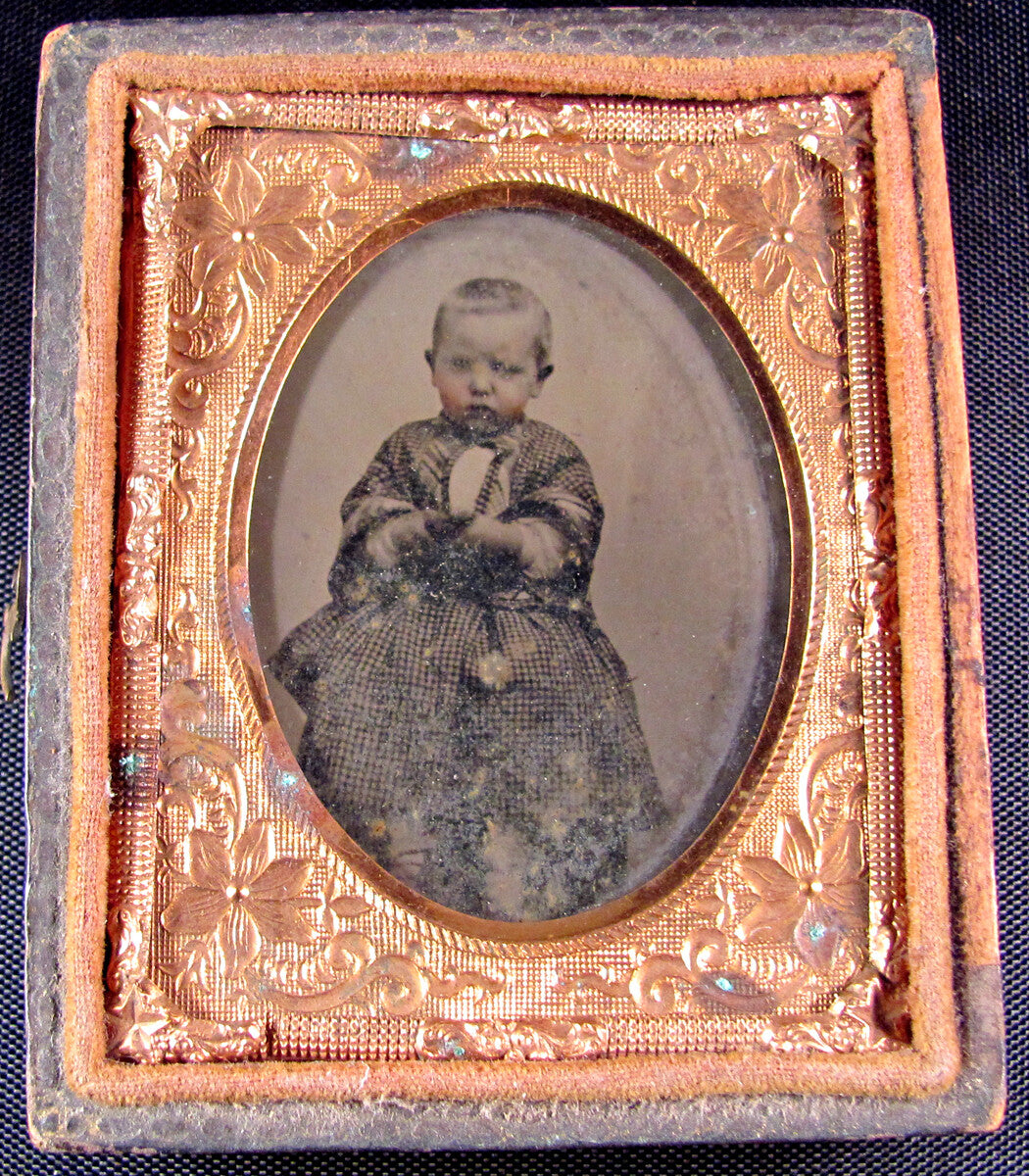 POUTY CHILD IN CHECKER DRESS. TINTED 9TH PLATE AMBROTYPE, HALF CASE.