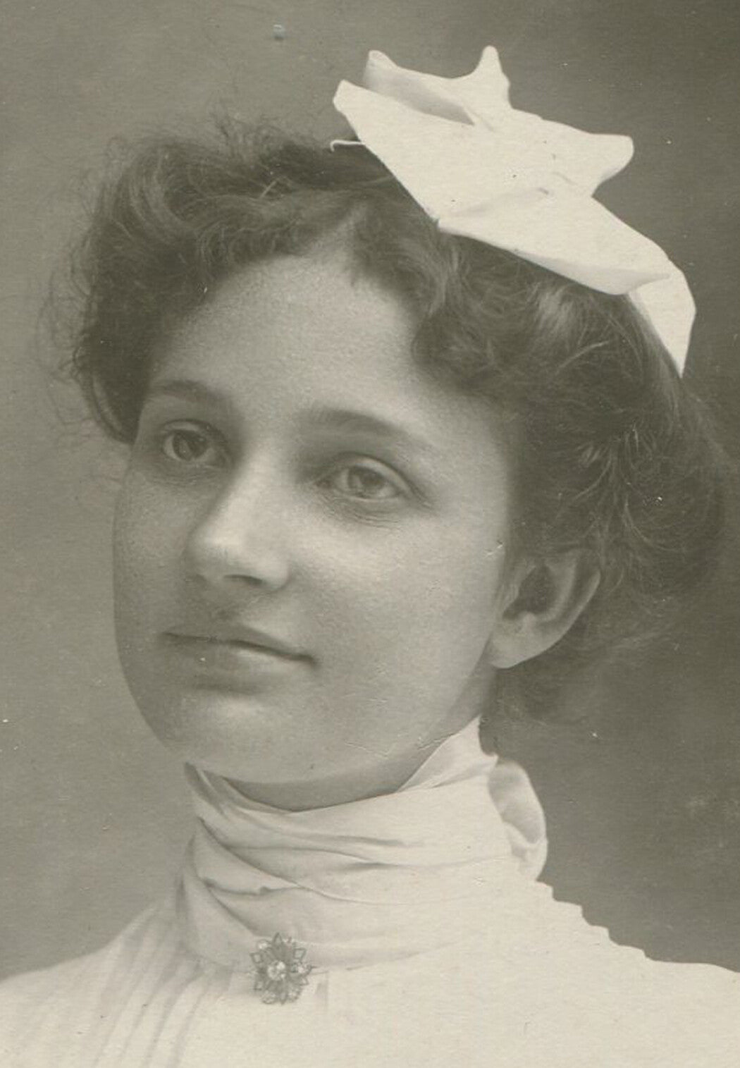 PRETTY WOMAN IN WHITE W/HANKY HAT. OVAL SILVER PRINT, 1900.