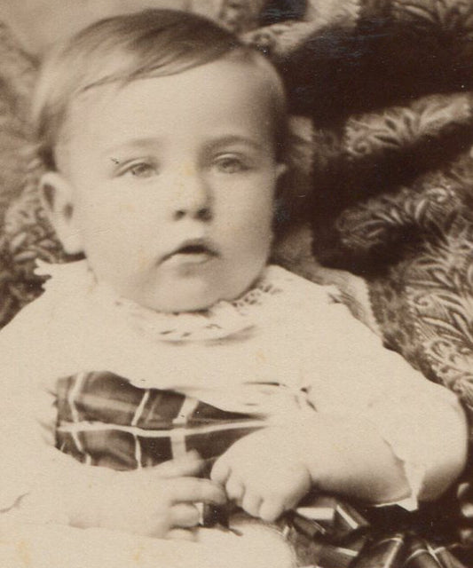 Vintage original cabinet card photo: sleepy baby in dress with plaid bow –