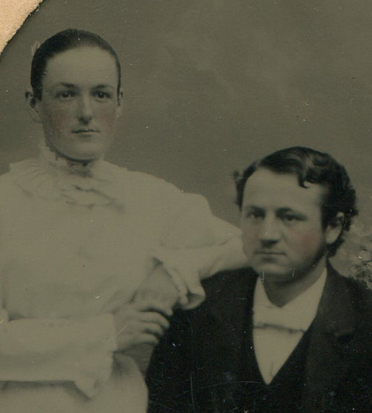 WOMAN LEANING ON MAN SEATED AT TABLE. TINTYPE IN PERIOD PAPER MAT.