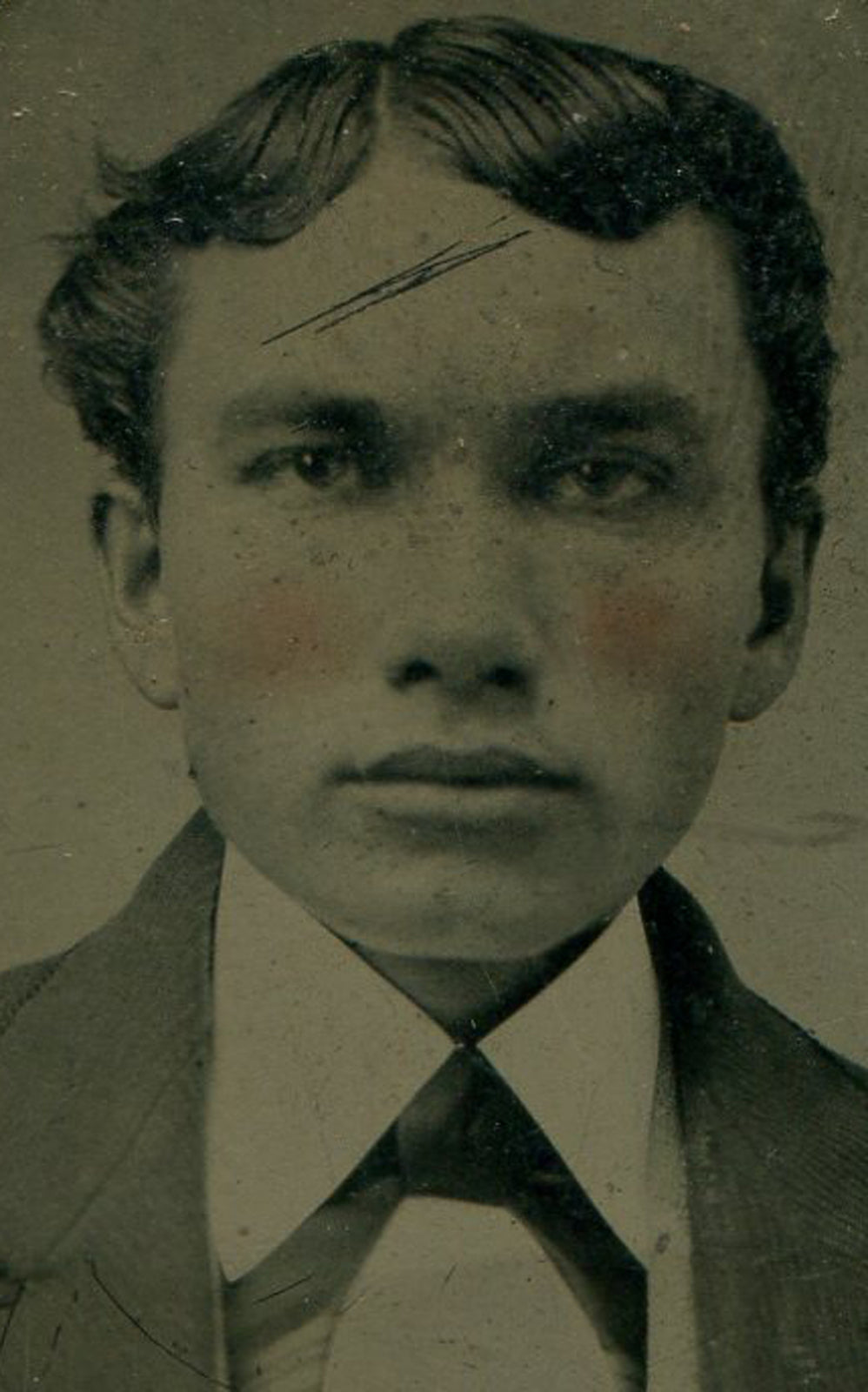 MAN W/ FULL LIPS, DEEP EYES. TINTED TINTYPE IN PERIOD PAPER MAT.