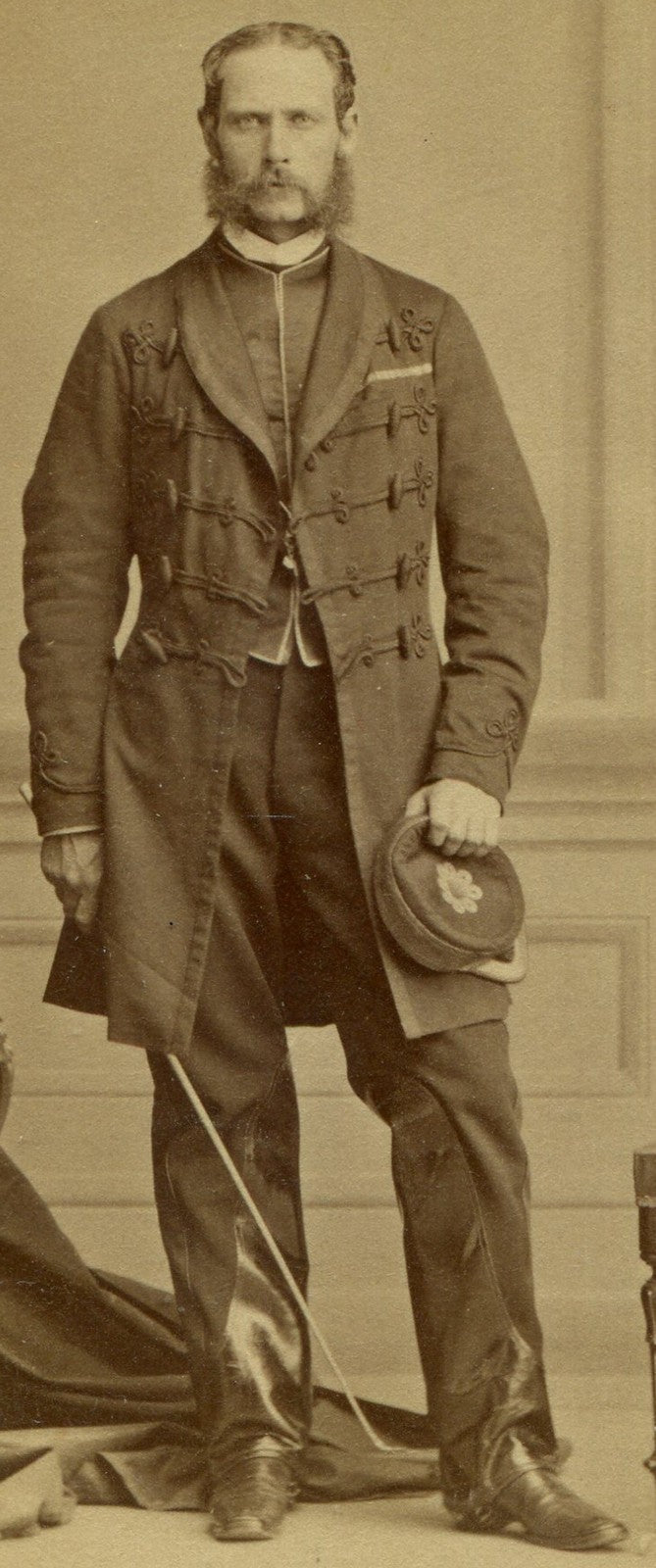 MAN IN ORNATE LONG COAT, KEPI, RIDING CROP, LEATHER TRIMMED PANTS. CDV. MONTREAL