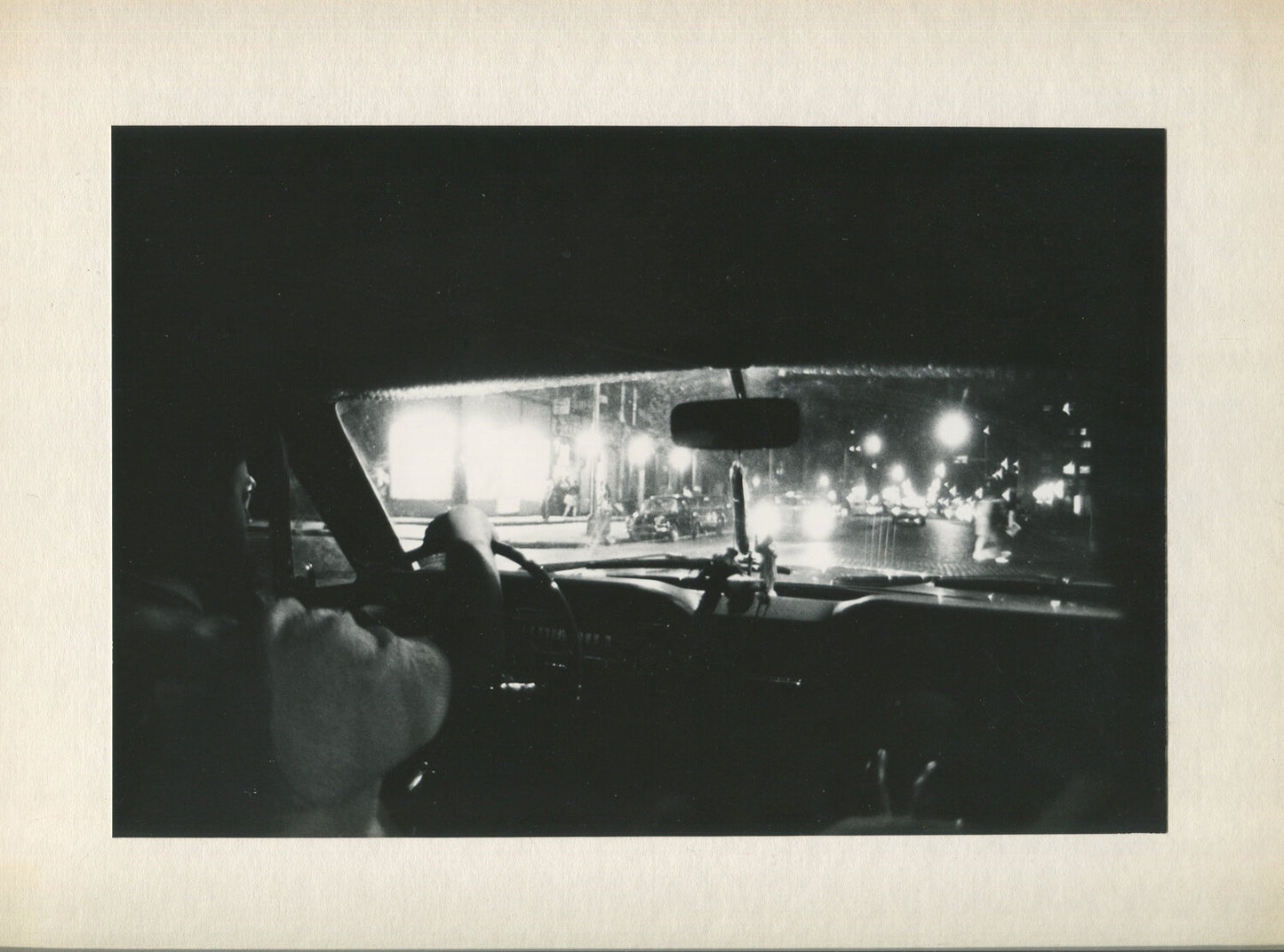 LOOKING THROUGH THE WINDSHIELD FROM THE BACK SEAT. B&W PHOTO, 1970s.