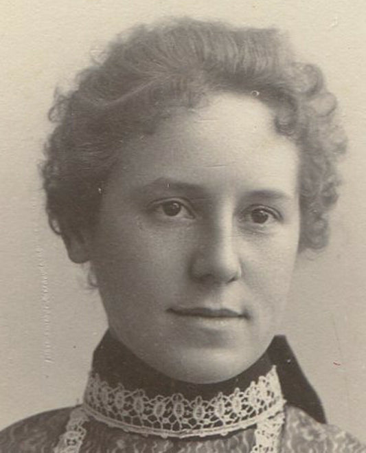 WOMAN, CURLY HAIR AND ORNATE DRESS. SCALLOPED EDGED CARD. 1900s. 4X3 INCHES.