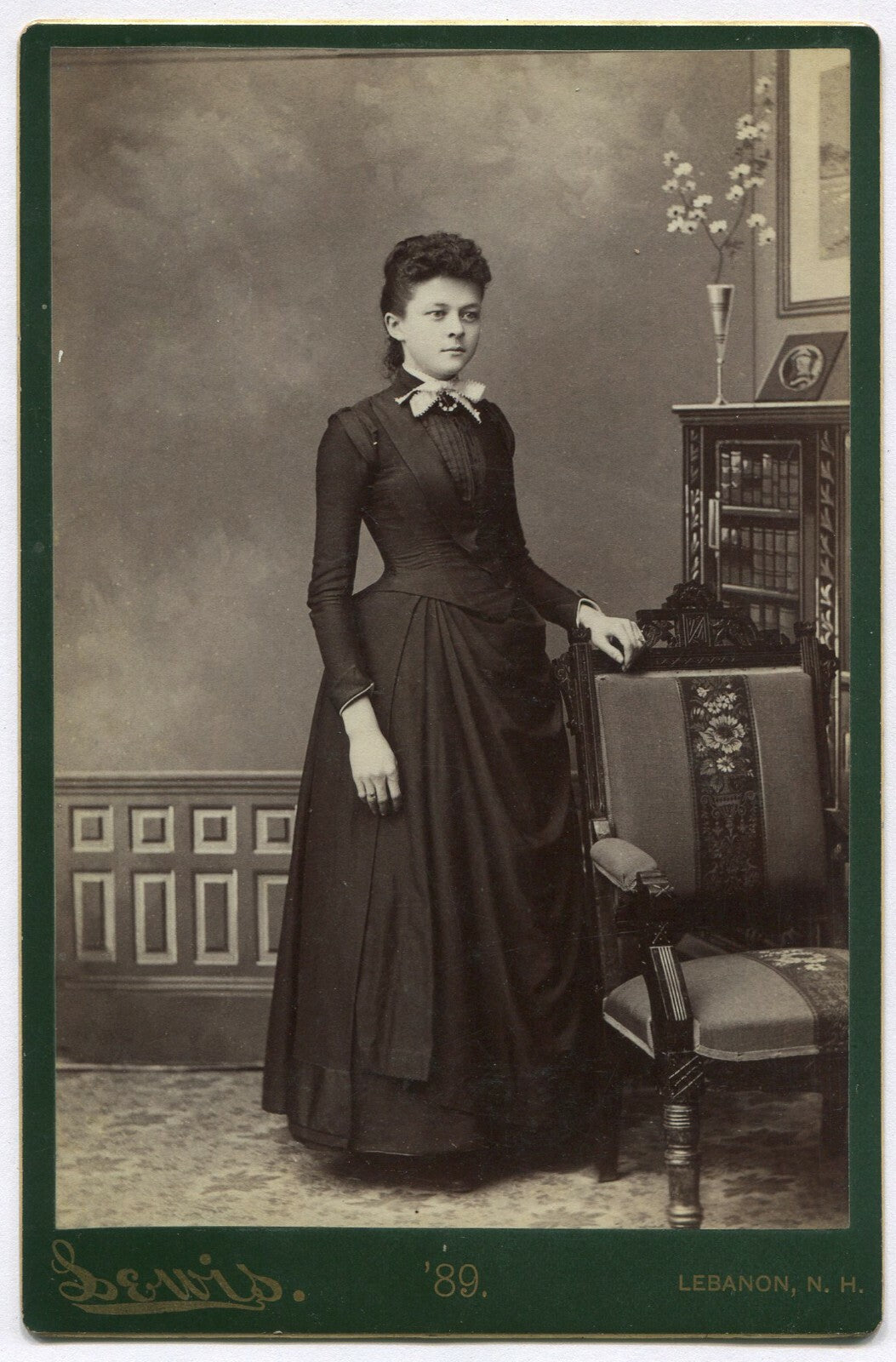 CURLY HAIRED WOMAN, STANDING POSE, ORNATE BACKGROUND. CABINET CARD, LEBANON, N.H