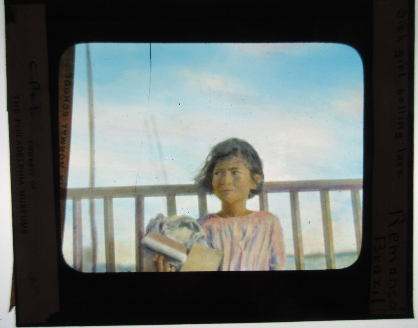 GIRL SELLING LACE, BRAZIL. HAND COLORED PHOTO ON GLASS.