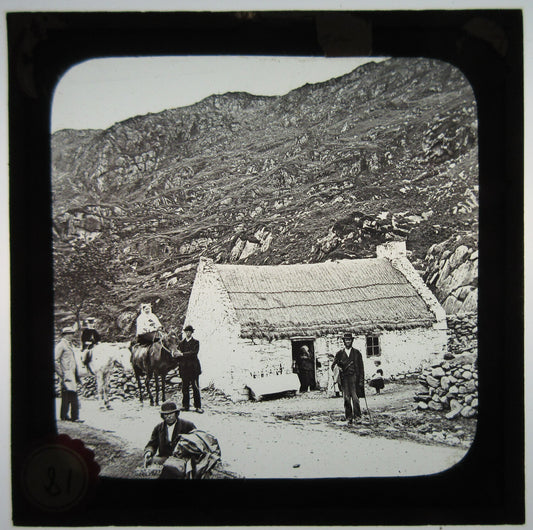 FAMILIES AND HORSES OUTSIDE COTTAGE WITH THATCHED ROOF. LANTERN SLIDE.