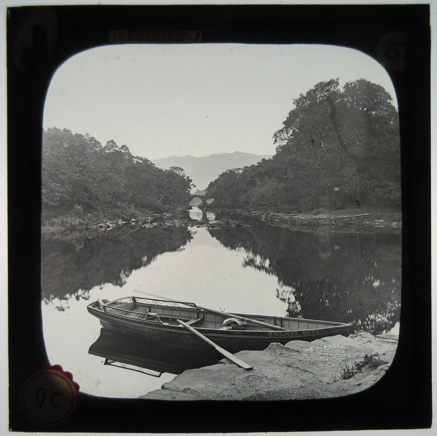 ROW BOAT AND STONE BRIDGE ON RIVER. IRELAND. LANTERN SLIDE.