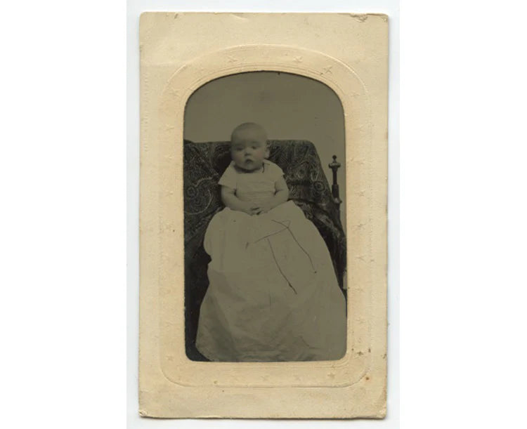 TINTYPE STUDIO PORTRAIT OF BABY IN LONG DRESS W/ TINTED CHEEKS