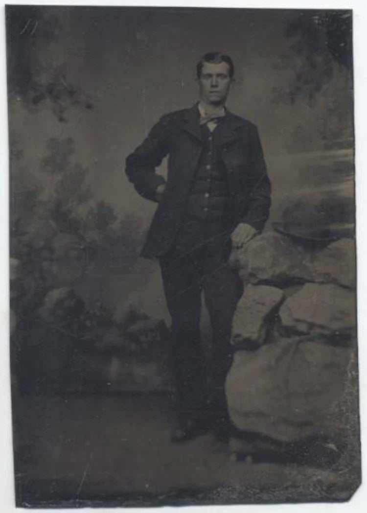 UNMOUNTED TINTYPE, TALL MAN POSING WITH ROCK FOR A PORTRAIT. PAINTED BACKDROP.