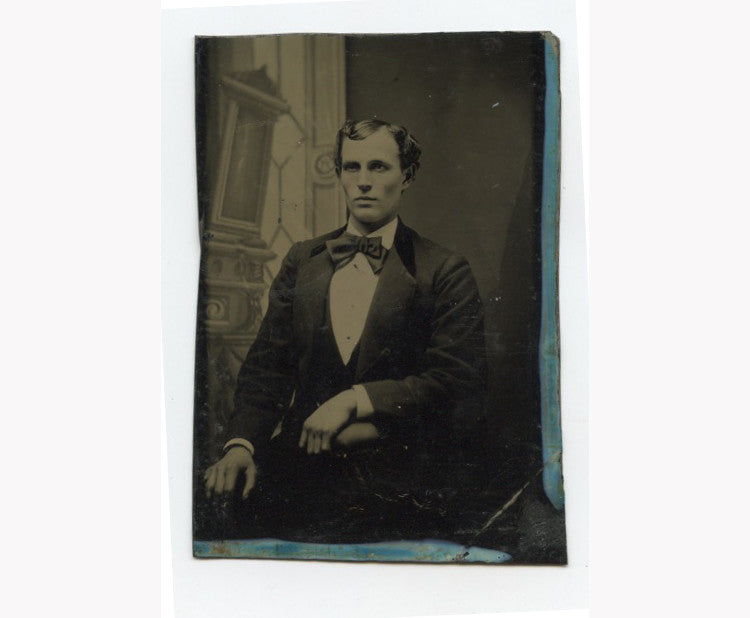 TINTYPE PORTRAIT MAN W/ BOW TIE SEATED BY PAINTED BACKGROUND, 1/6 PLATE