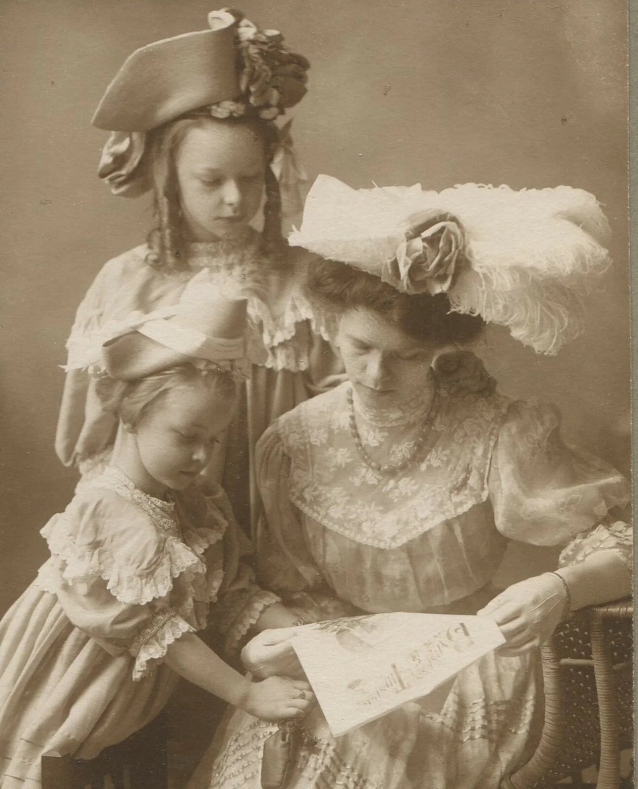MOTHER W/DAUGHTERS IN VERY FANCY HATS. 5.25X3X5.5IN TONED SILVER PRINT.