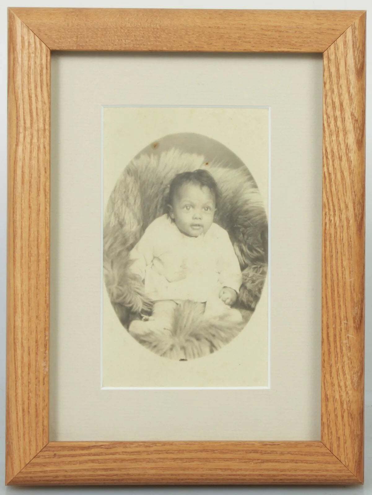 AFRICAN AMERICAN BABY POSED ON FUR BLANKET. CABINET CARD IN 5X7 FRAME.