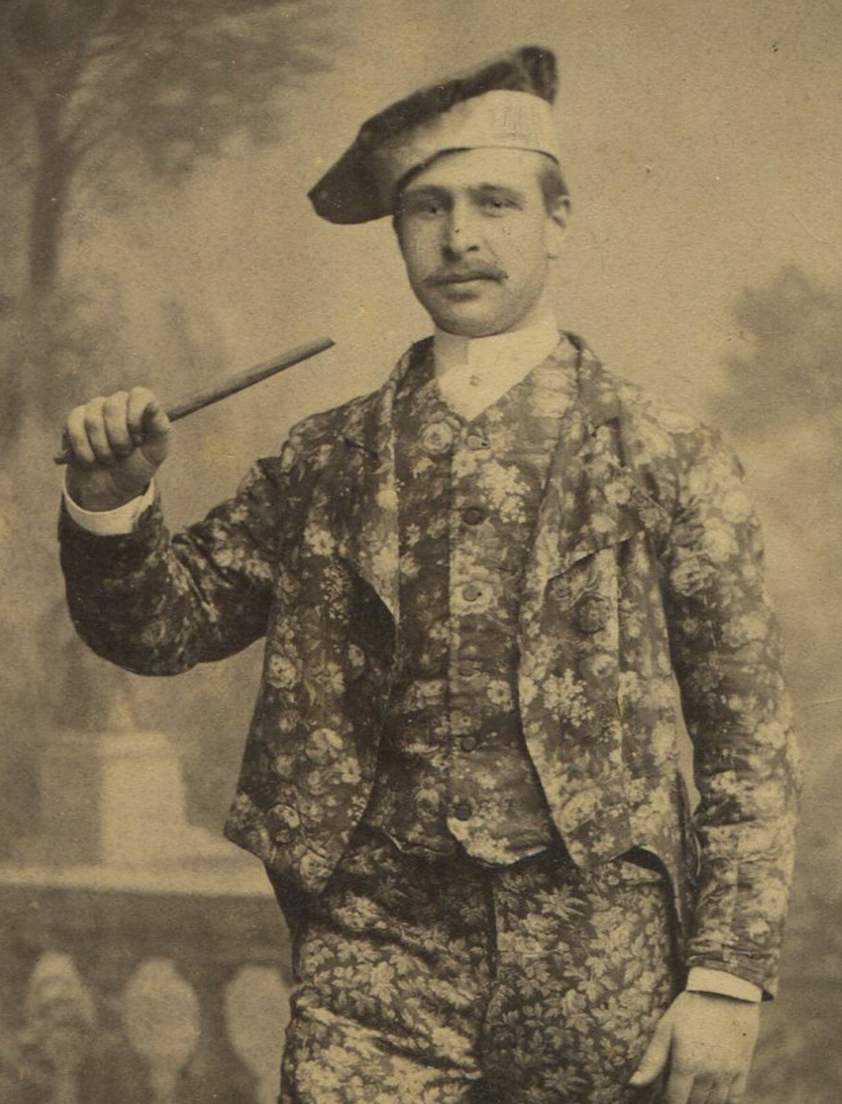 PERFORMER/MAGICIAN IN RICHLY PATTERNED SUIT. CABINET CARD.