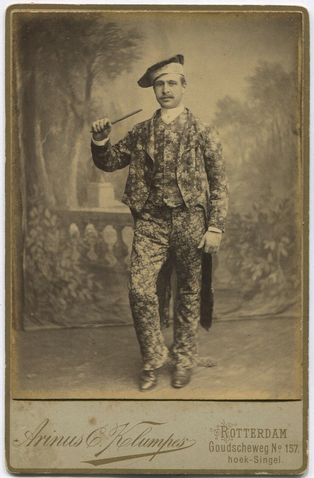 PERFORMER/MAGICIAN IN RICHLY PATTERNED SUIT. CABINET CARD.
