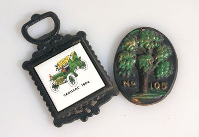 CAST IRON VINTAGE WALL HANGERS. SET OF 2. 1904 CADILLAC AND NO. 105